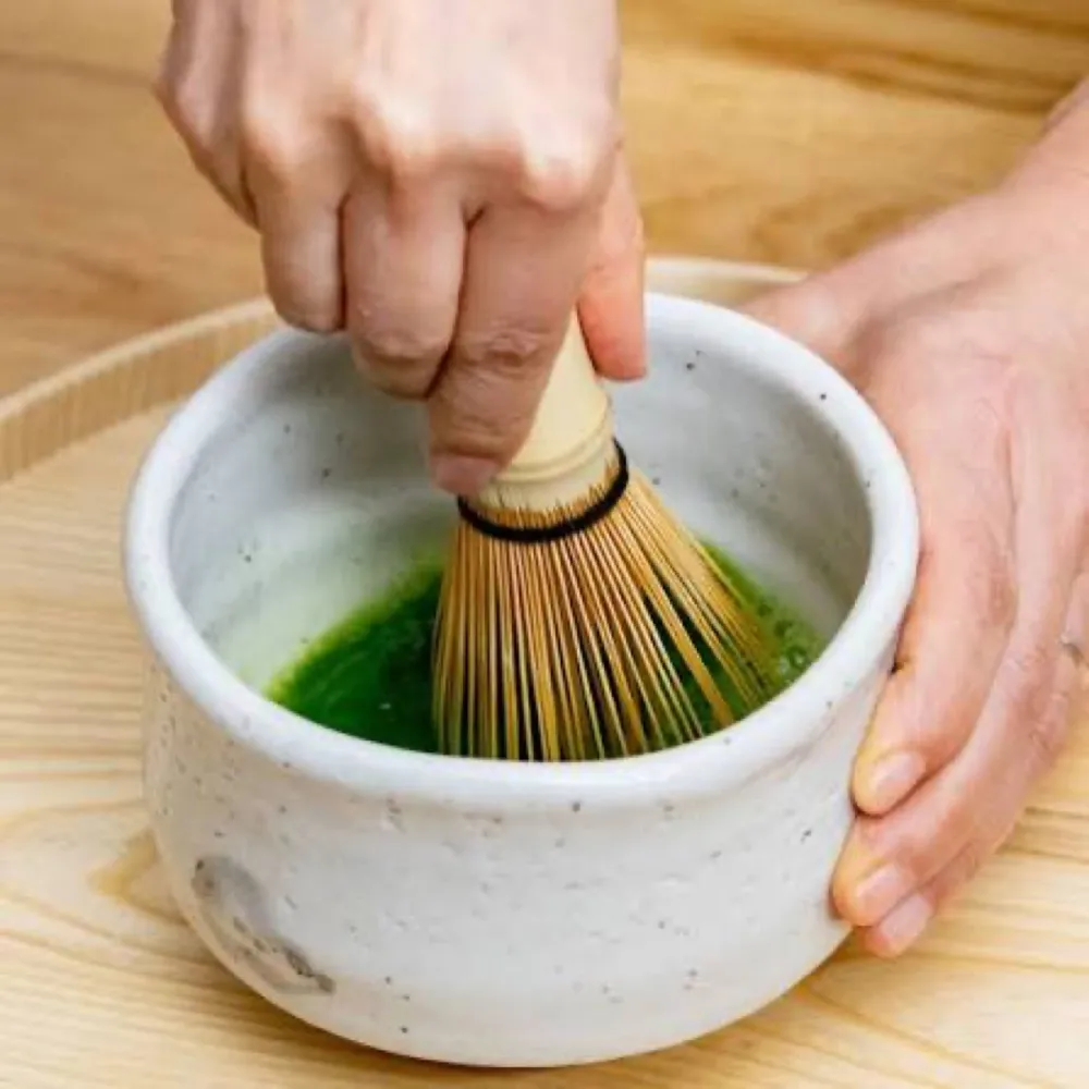 Batiendo matcha con un chasen de bambú en el chawan